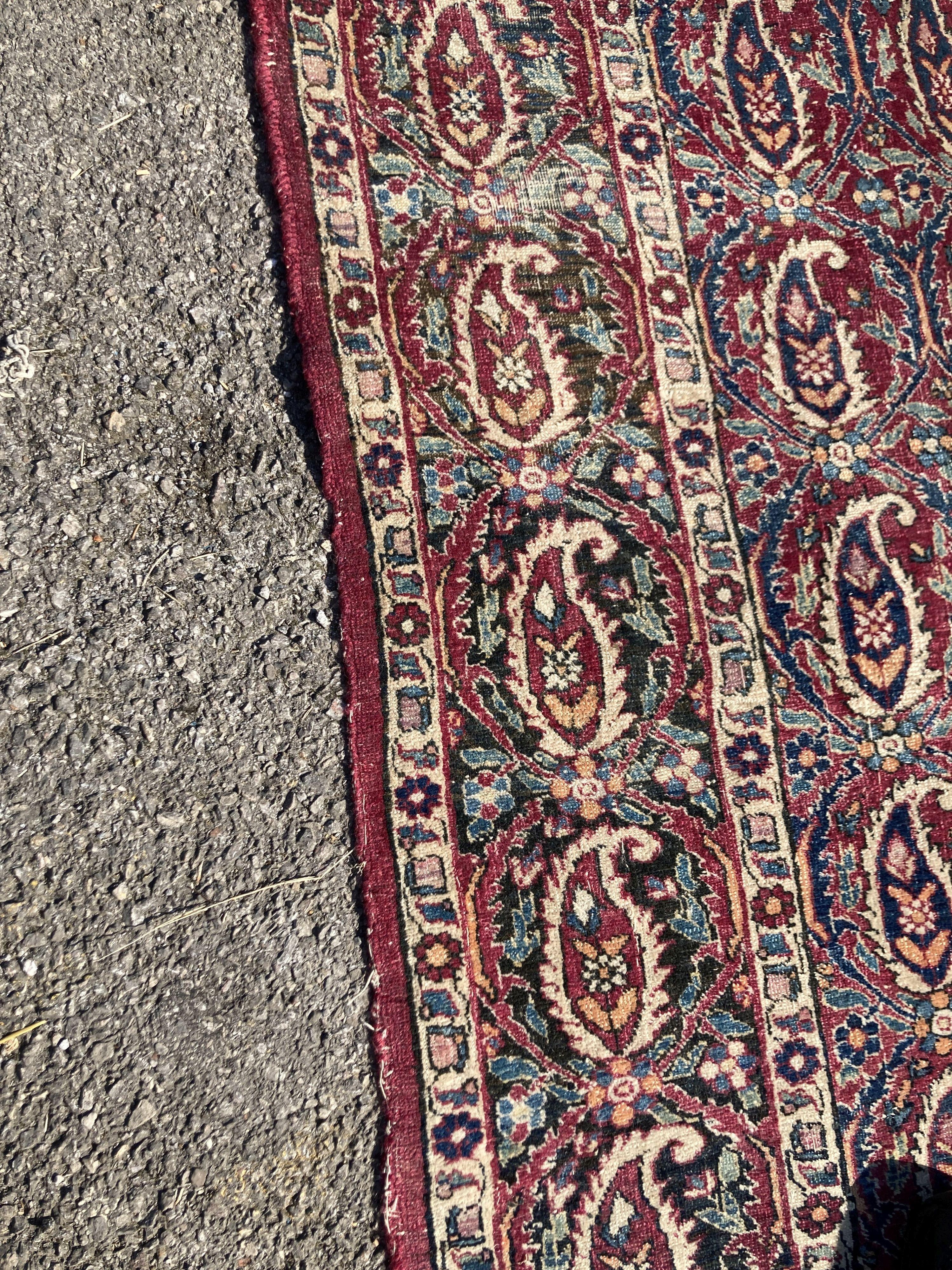 An early 20th century Persian Senneh red ground rug woven with rows of Boteh 218 x 130 cms